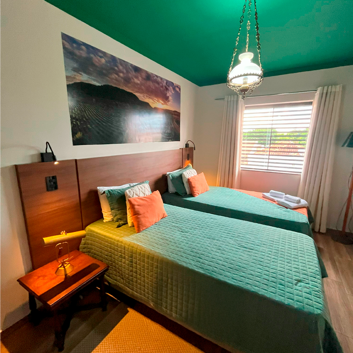 Um quarto com duas camas e um teto verde Hotel Barra Bonita