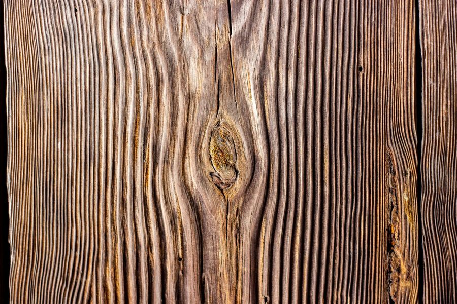 Close-up of weathered brown wood planks with visible grain and knots