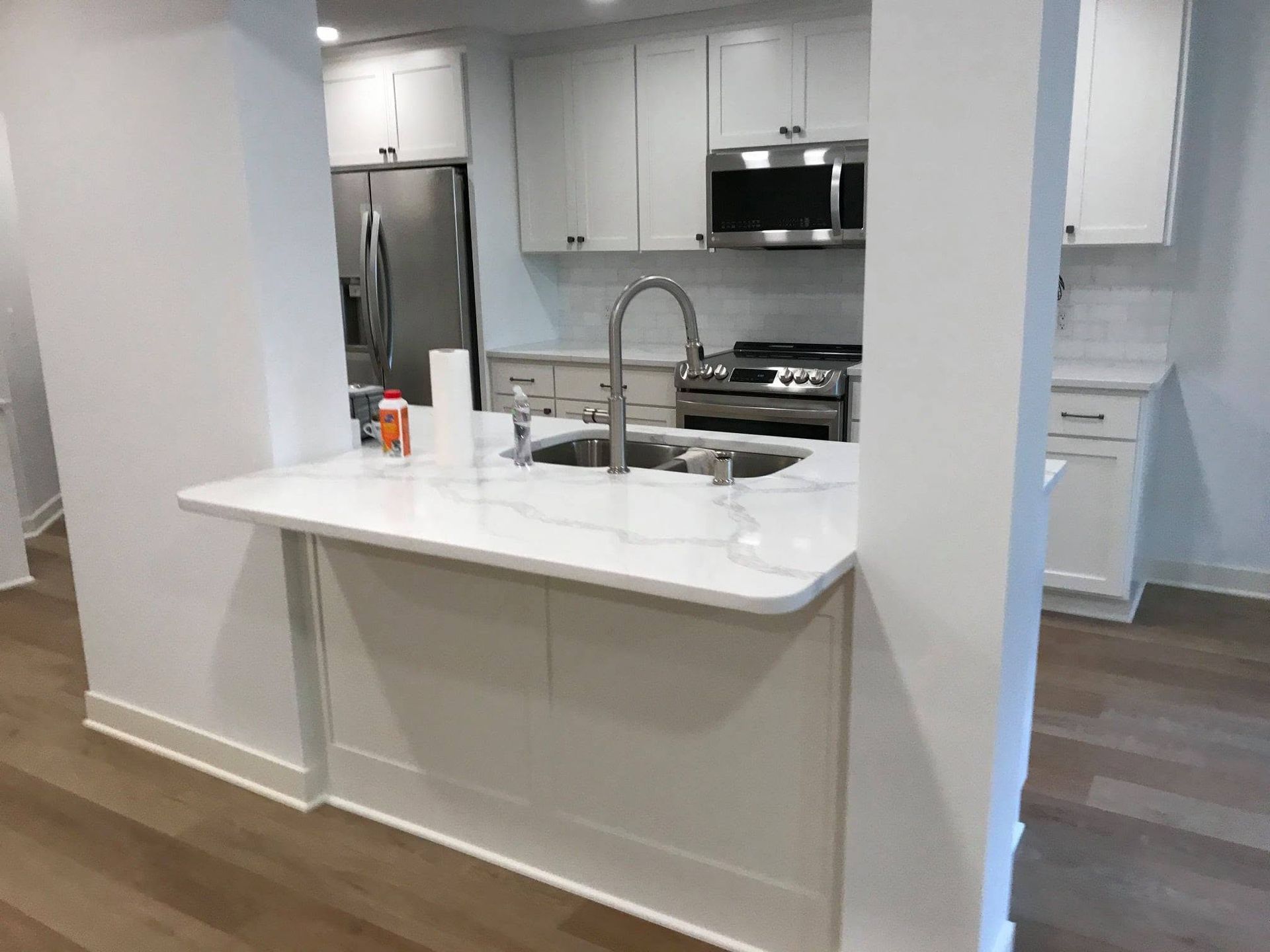 Modern kitchen with white island, stainless steel appliances, and gray walls