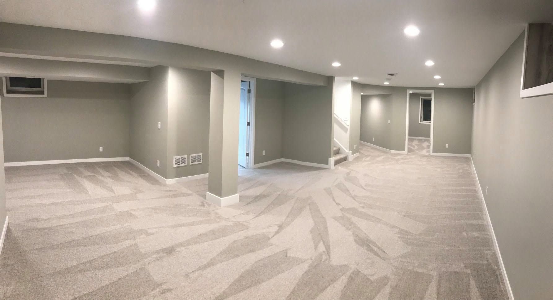 Empty finished basement room with gray carpet, recessed lights, and beige walls