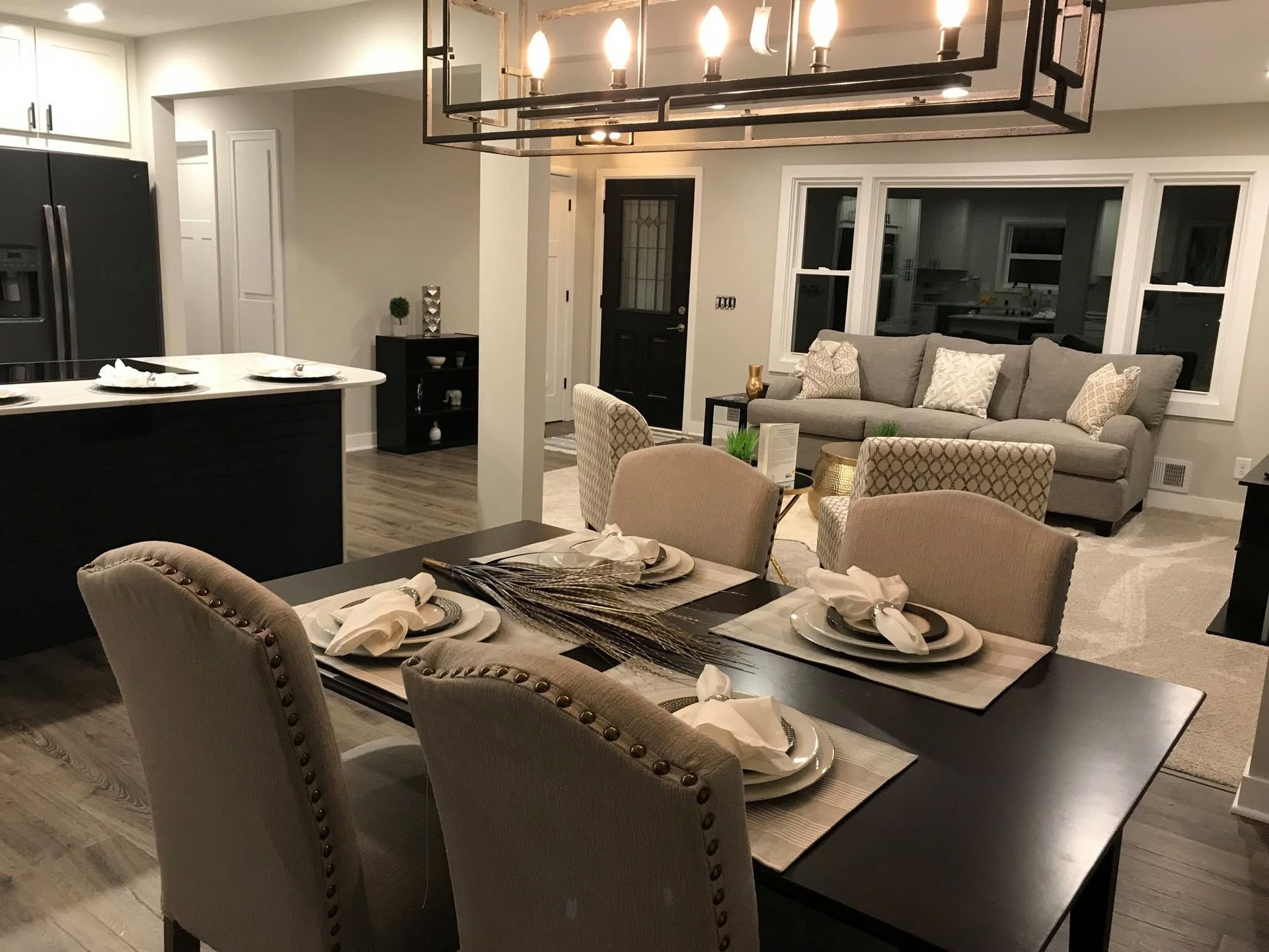Open-concept dining room with set table, kitchen island, and living area beyond