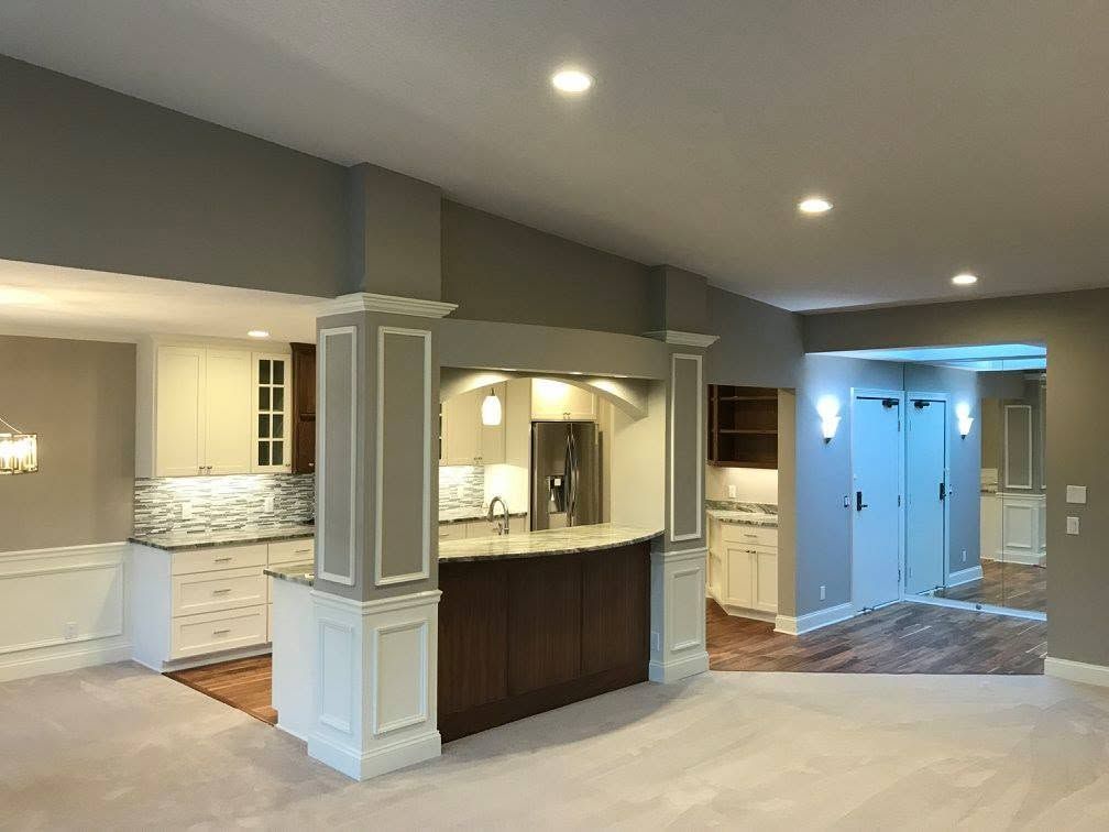Open-concept kitchen and foyer with white cabinets, dark island, and recessed ceiling lights