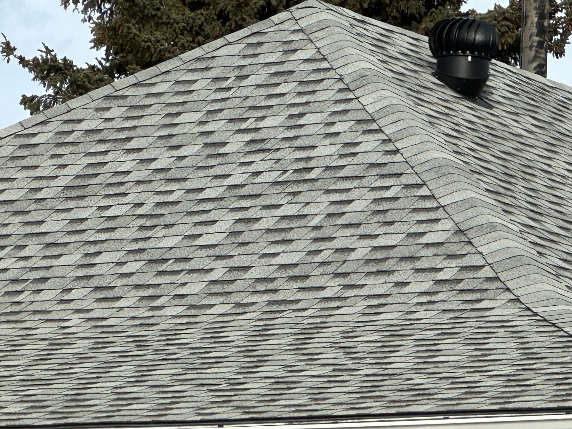A house with a brown tiled roof and two chimneys.