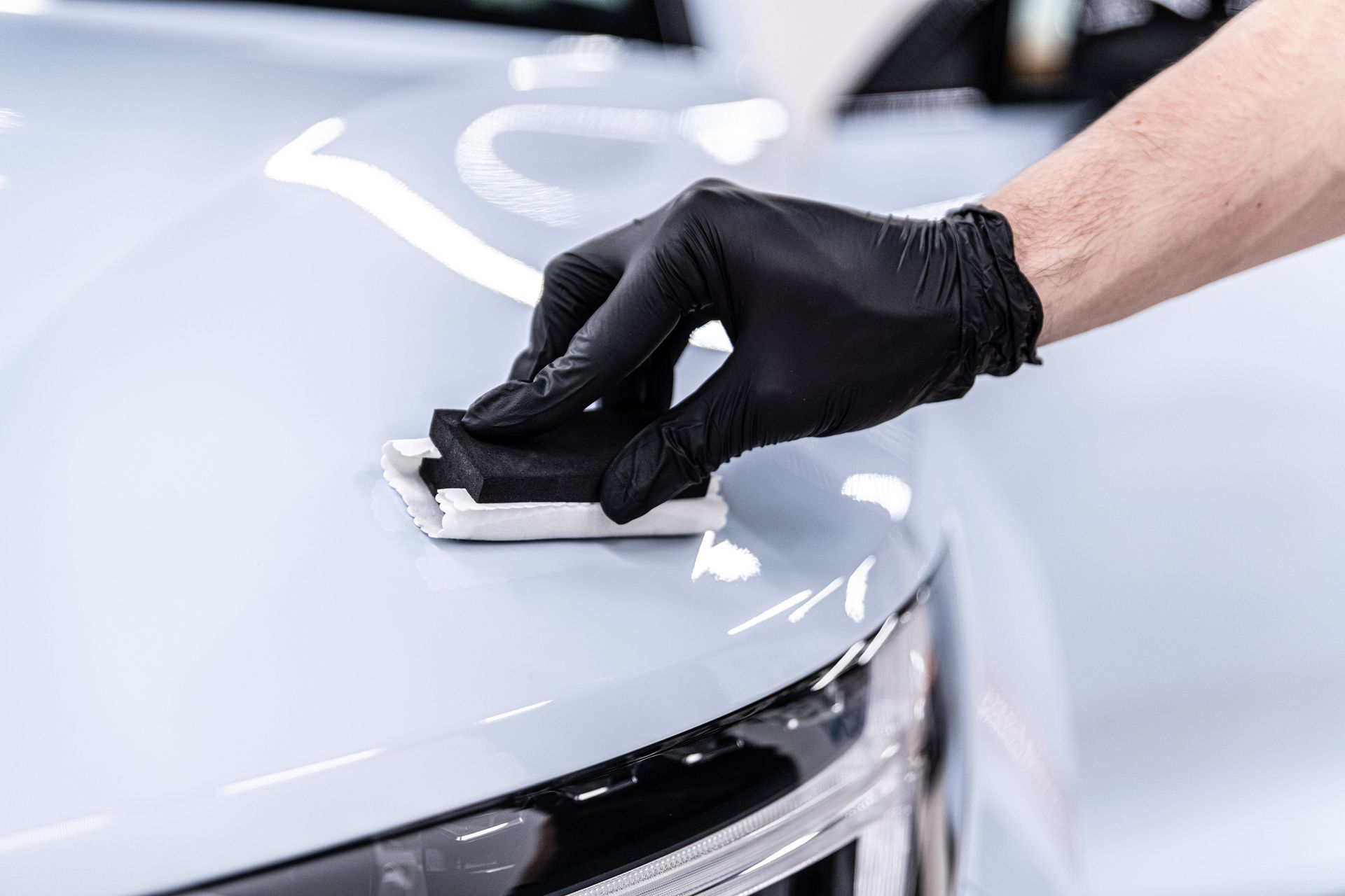 A man is giving final touches to a car.