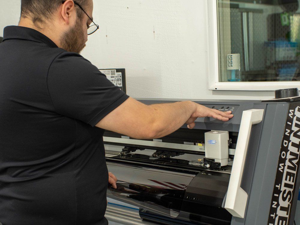 A man in a black shirt is working on a machine that says infinity