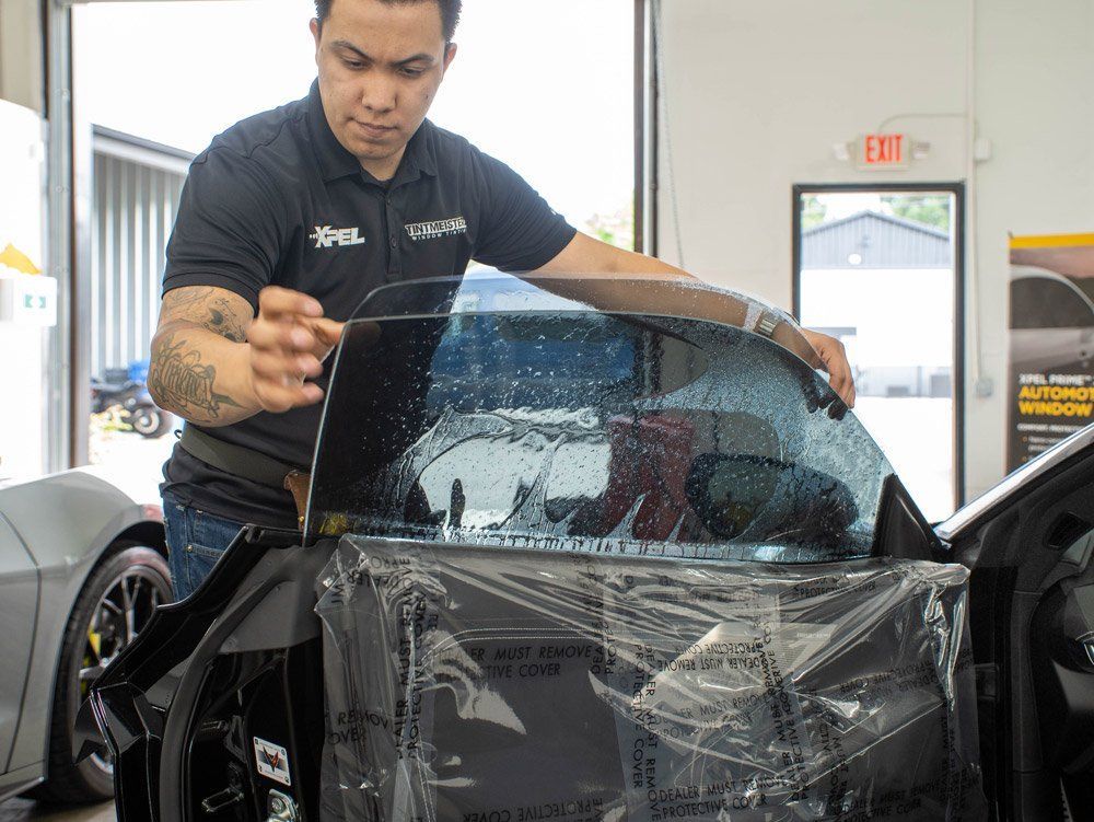 A man is applying window tinting to a car.