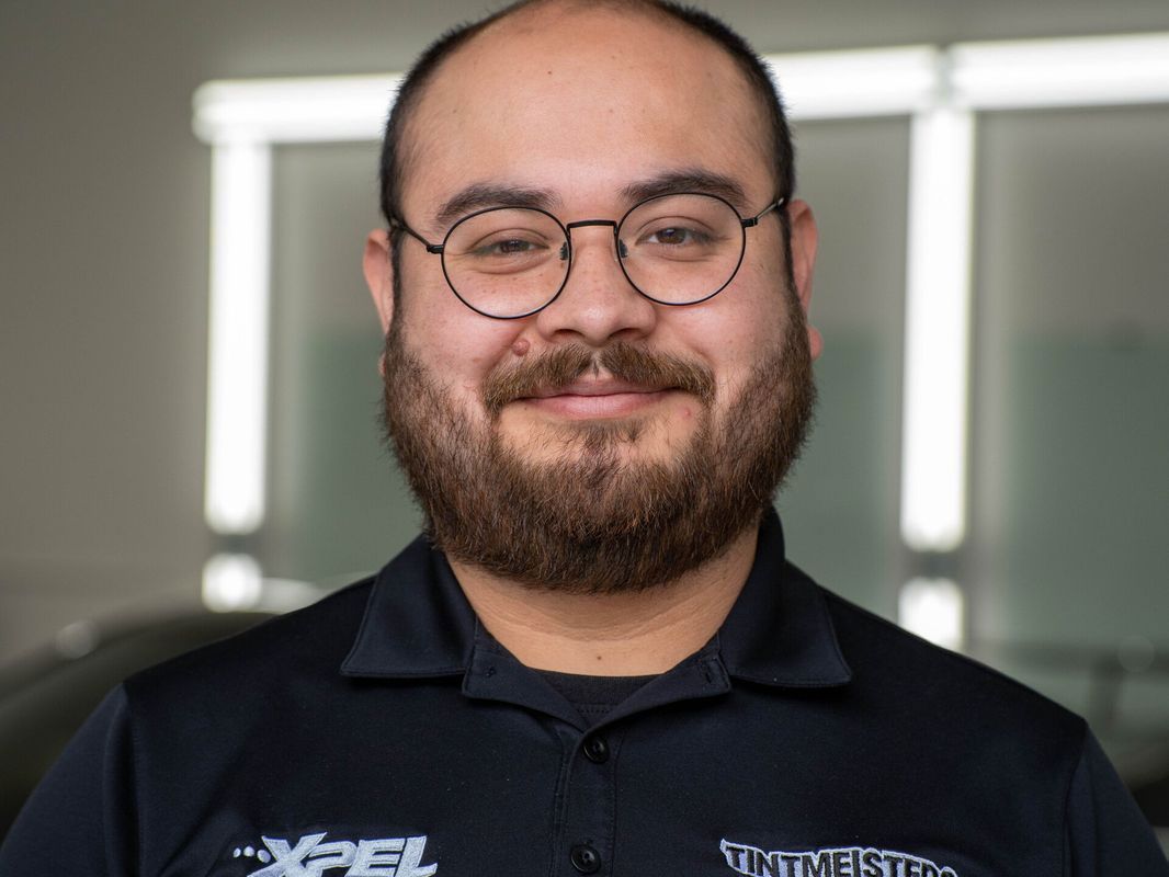 A man with a beard and glasses is smiling for the camera.