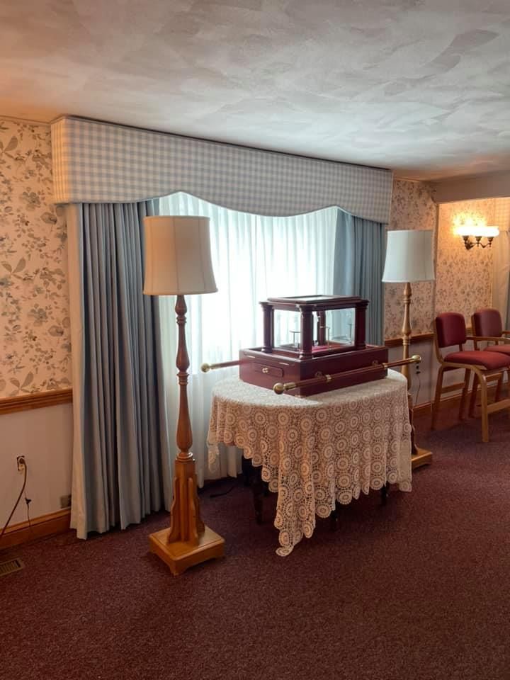 A room with two lamps and a table with a box on it