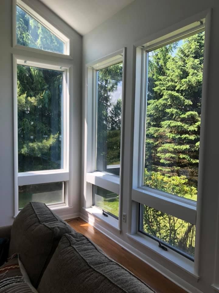 A living room with a couch and lots of windows.