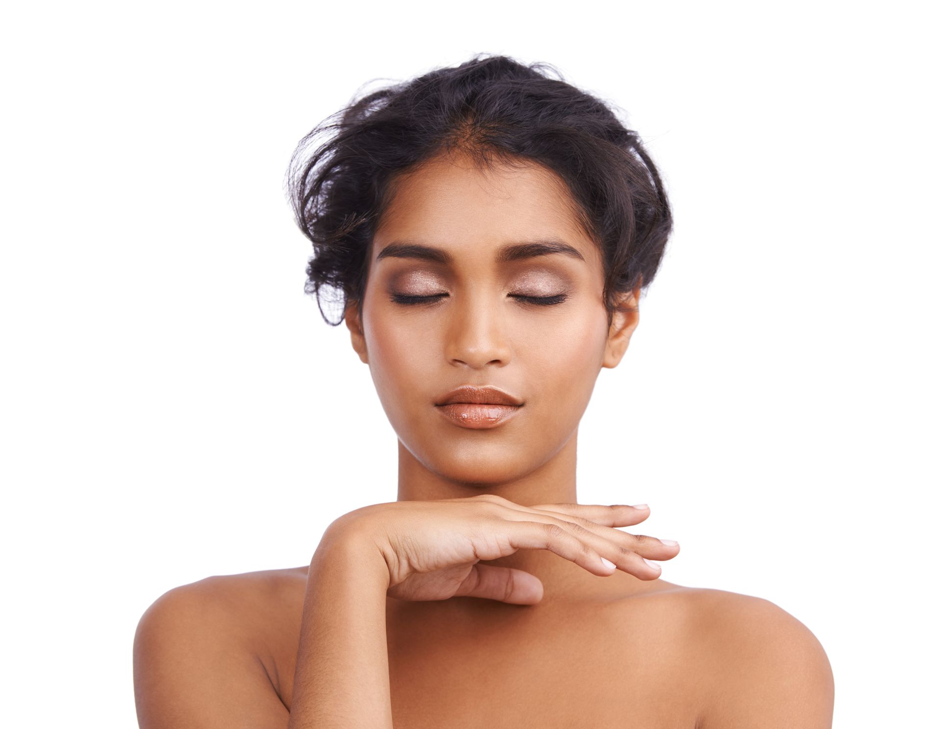 Portrait of a woman with eyes closed and hands resting under her chin against a white background