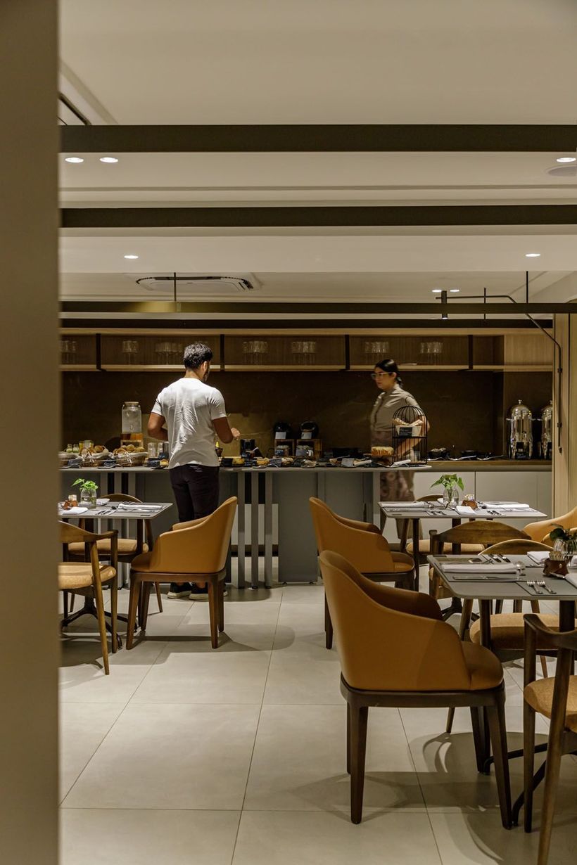 Um restaurante com mesas e cadeiras e uma parede de madeira.