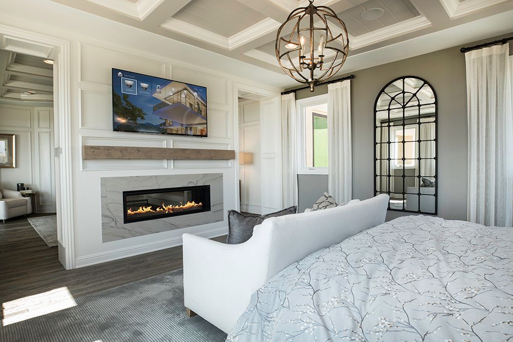 A bedroom with a fireplace and a flat screen tv on the wall.
