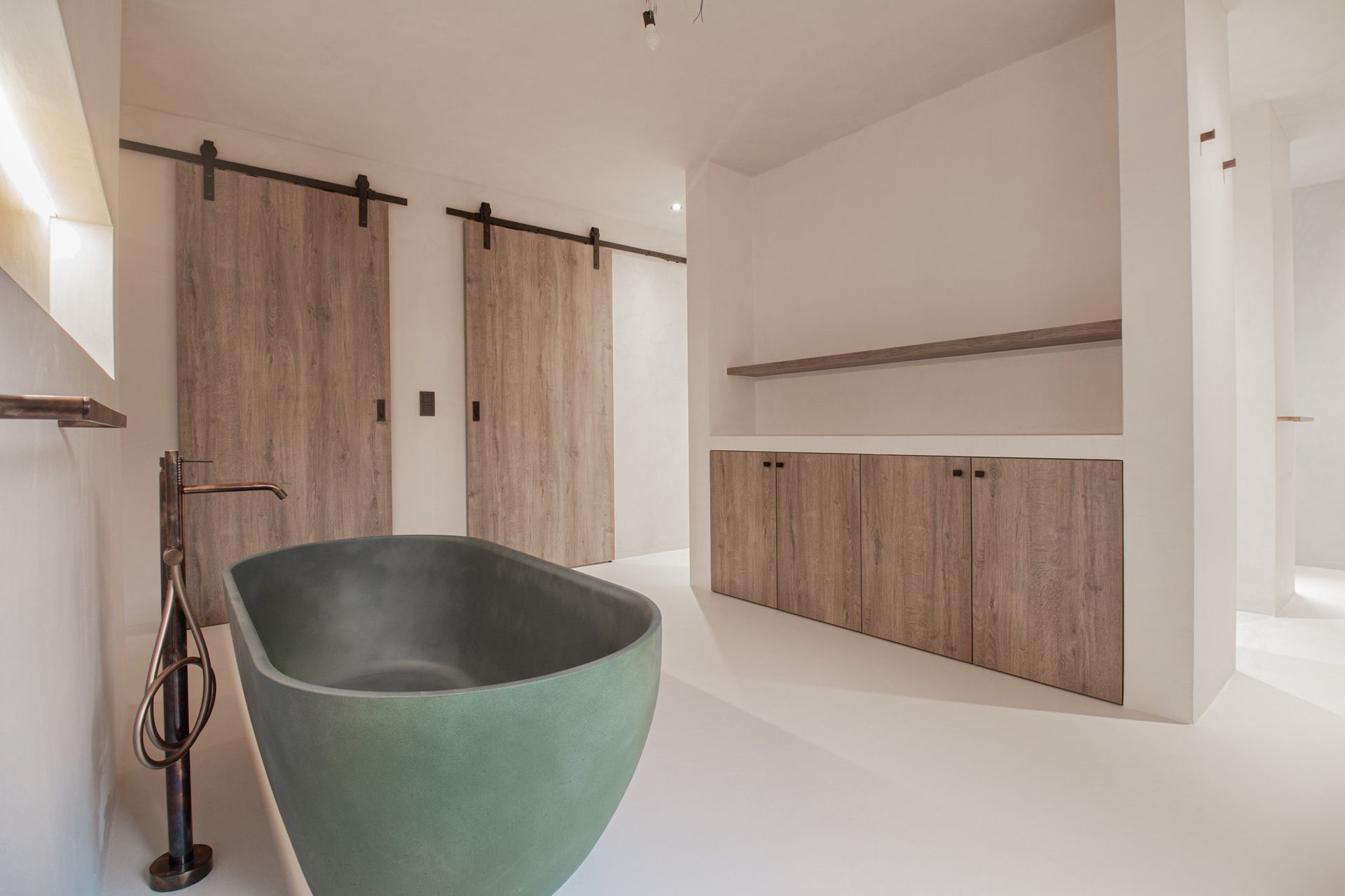 Moderne wachtkamer met bruine stoelen, kleine tafeltjes en kamerhoge ramen met uitzicht op het groen.