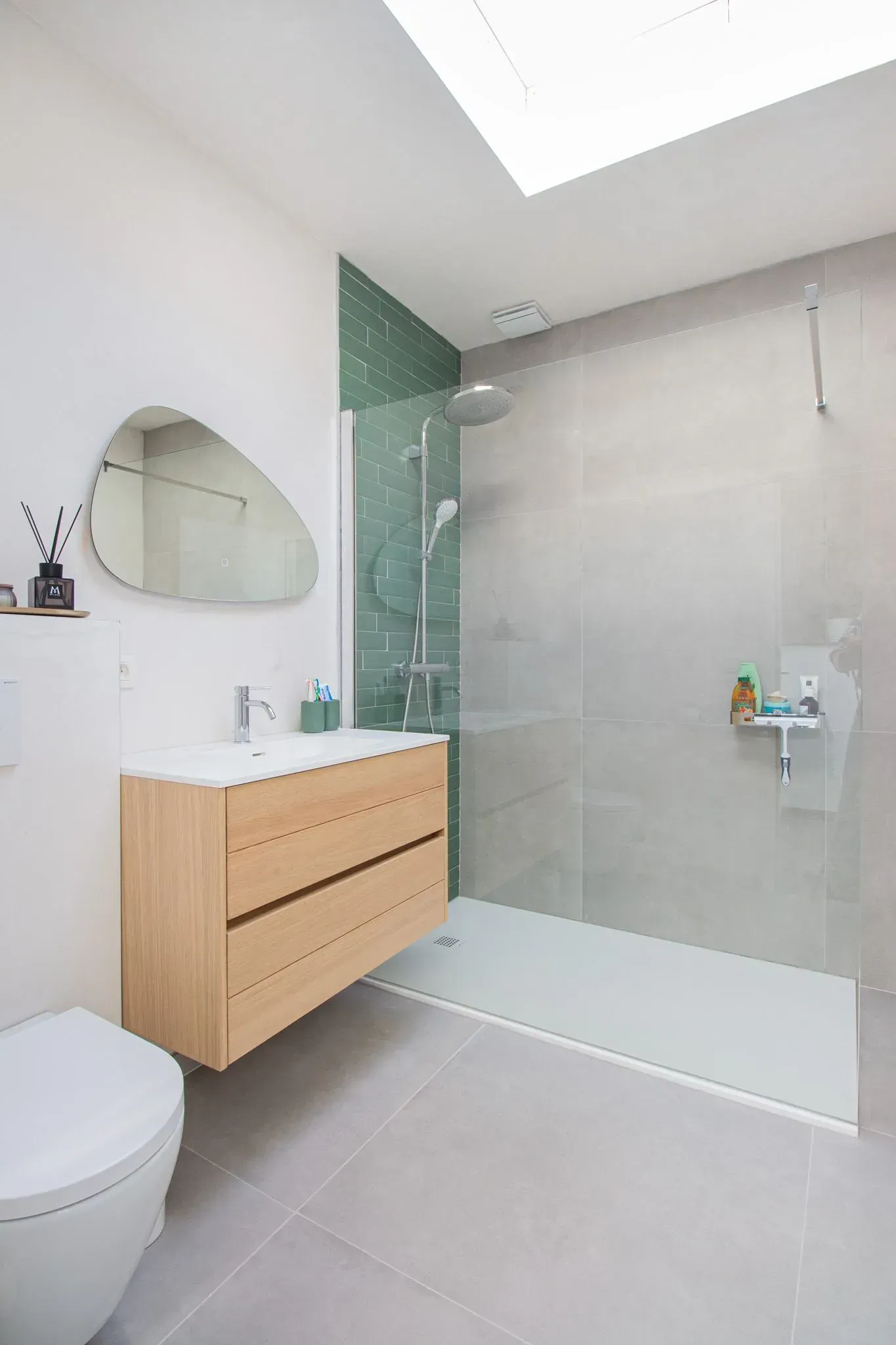 Moderne badkamer met houten wastafel, inloopdouche en geometrische spiegel.