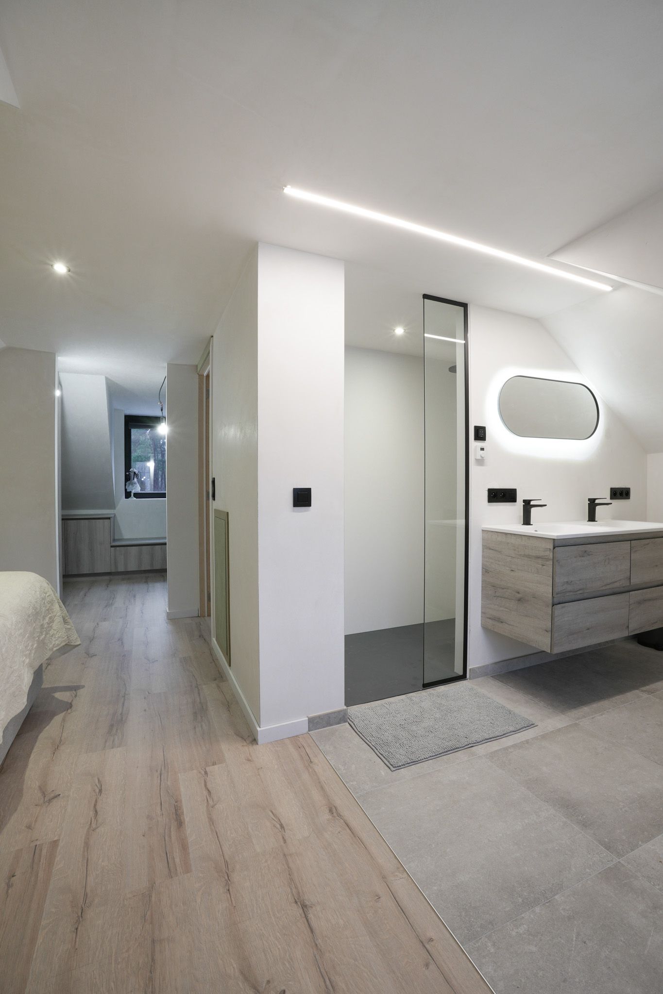 Moderne badkamer met glazen douche, zwevend wastafelmeubel en neutrale tinten.