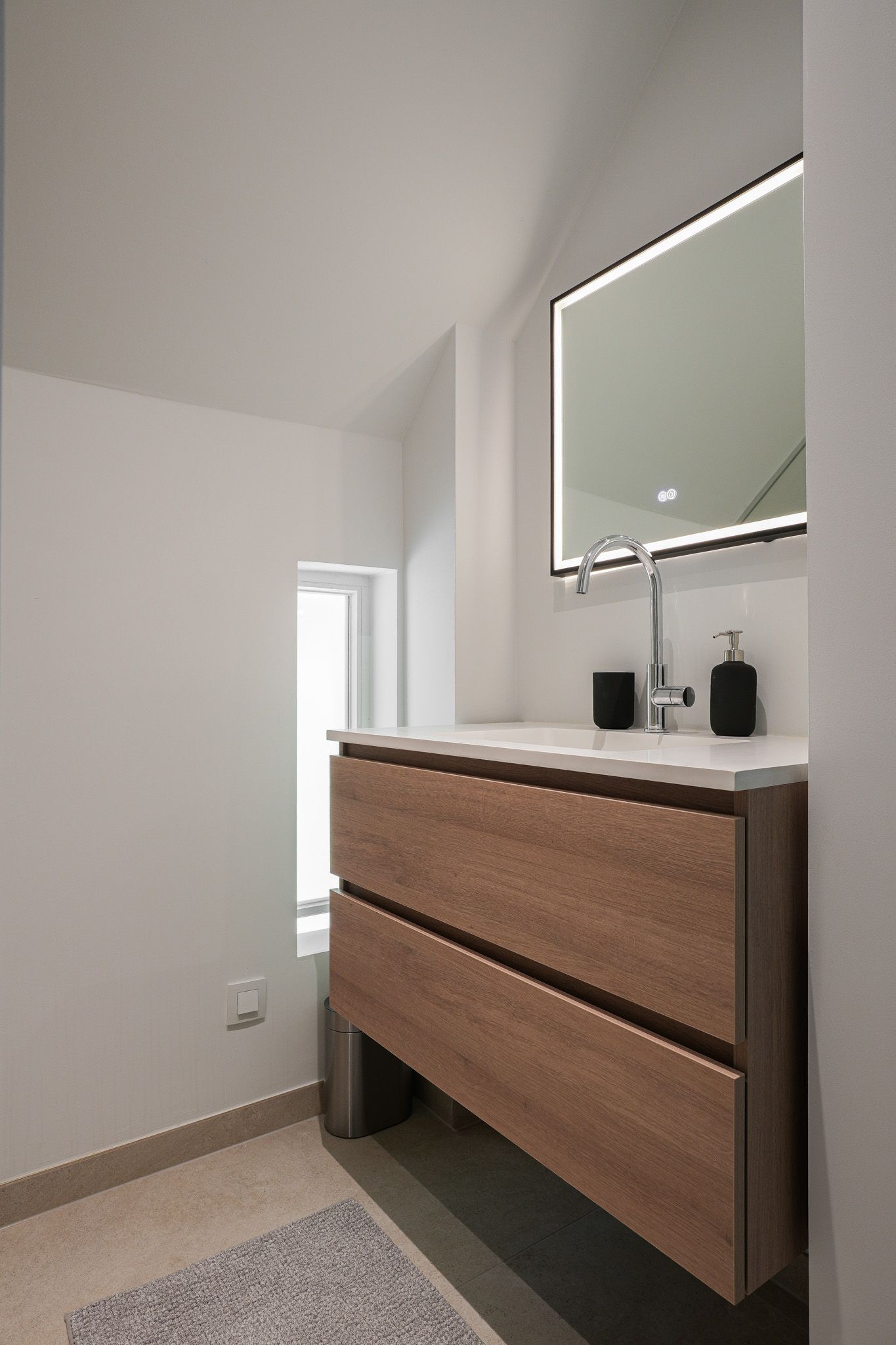Moderne badkamer met houten wastafel, rechthoekige spiegel en raam.