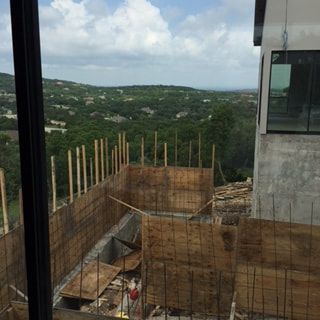 A building under construction with a view of a forest.