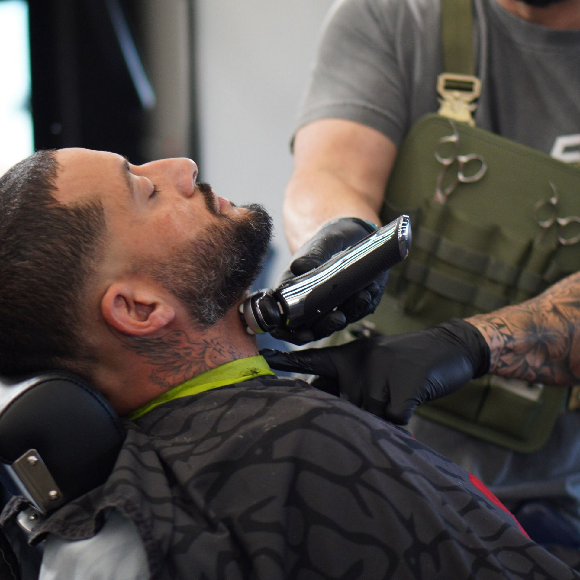 Tattoo artist styling a short-haired client's hair in a salon