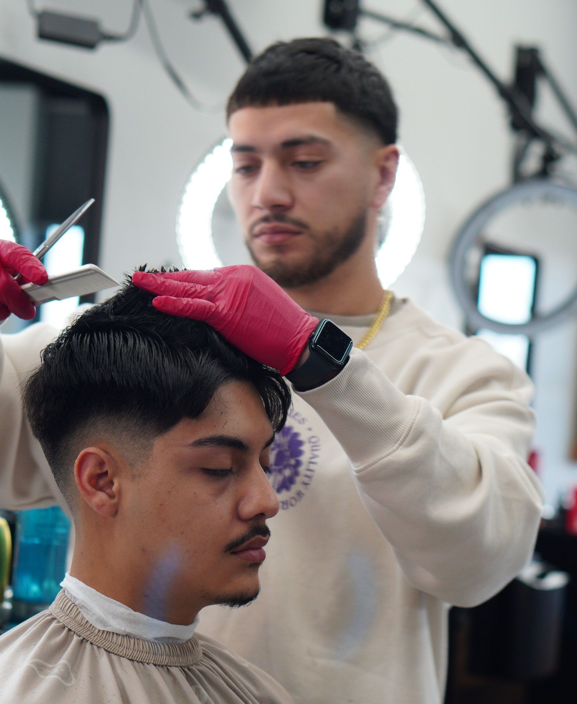 Tattoo artist styling a short-haired client's hair in a salon