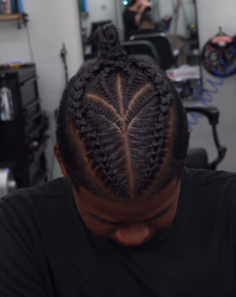 Close-up of a braided hairstyle with a bun, viewed from above in a salon chair