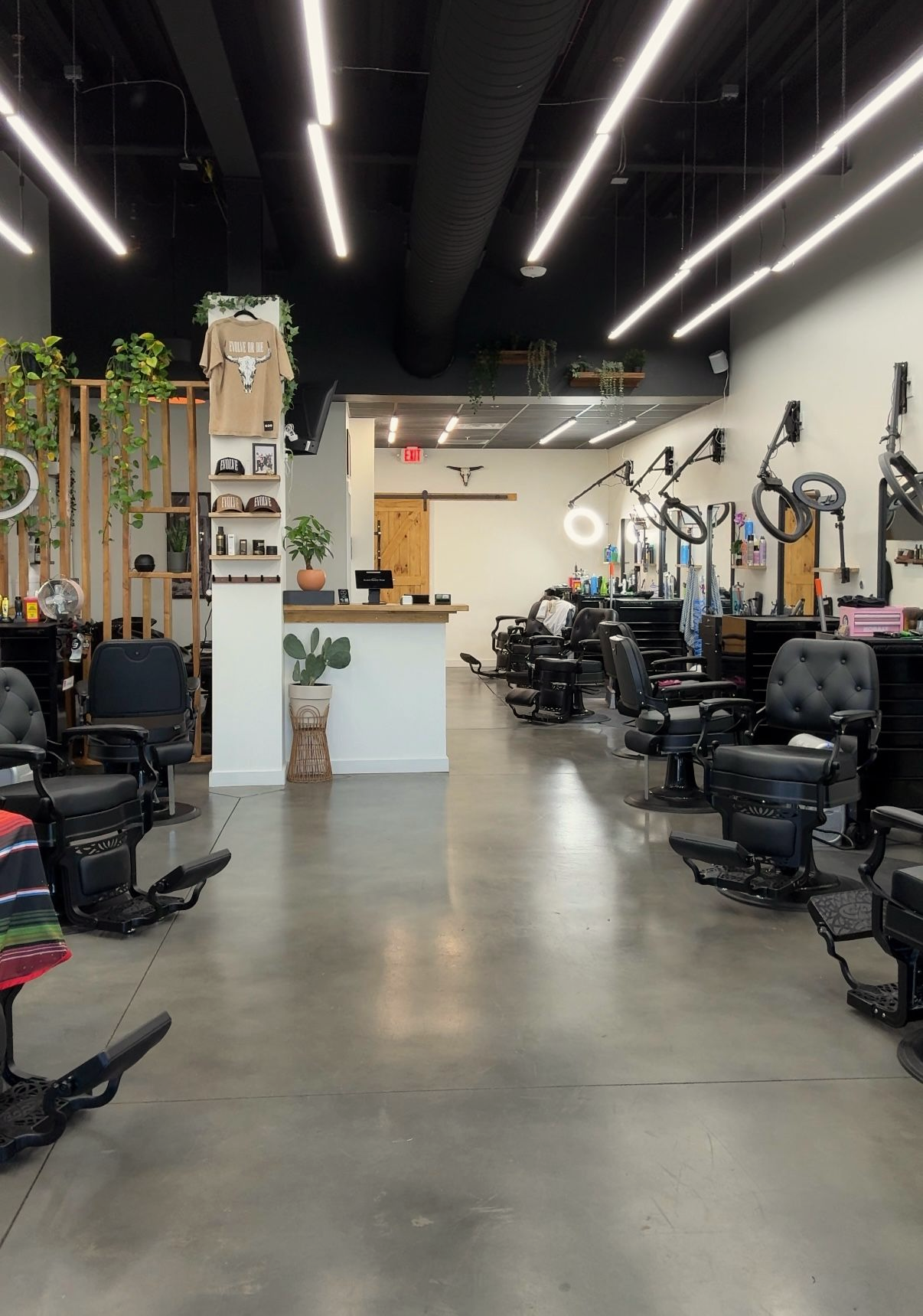 Tattoo artist styling a short-haired client's hair in a salon