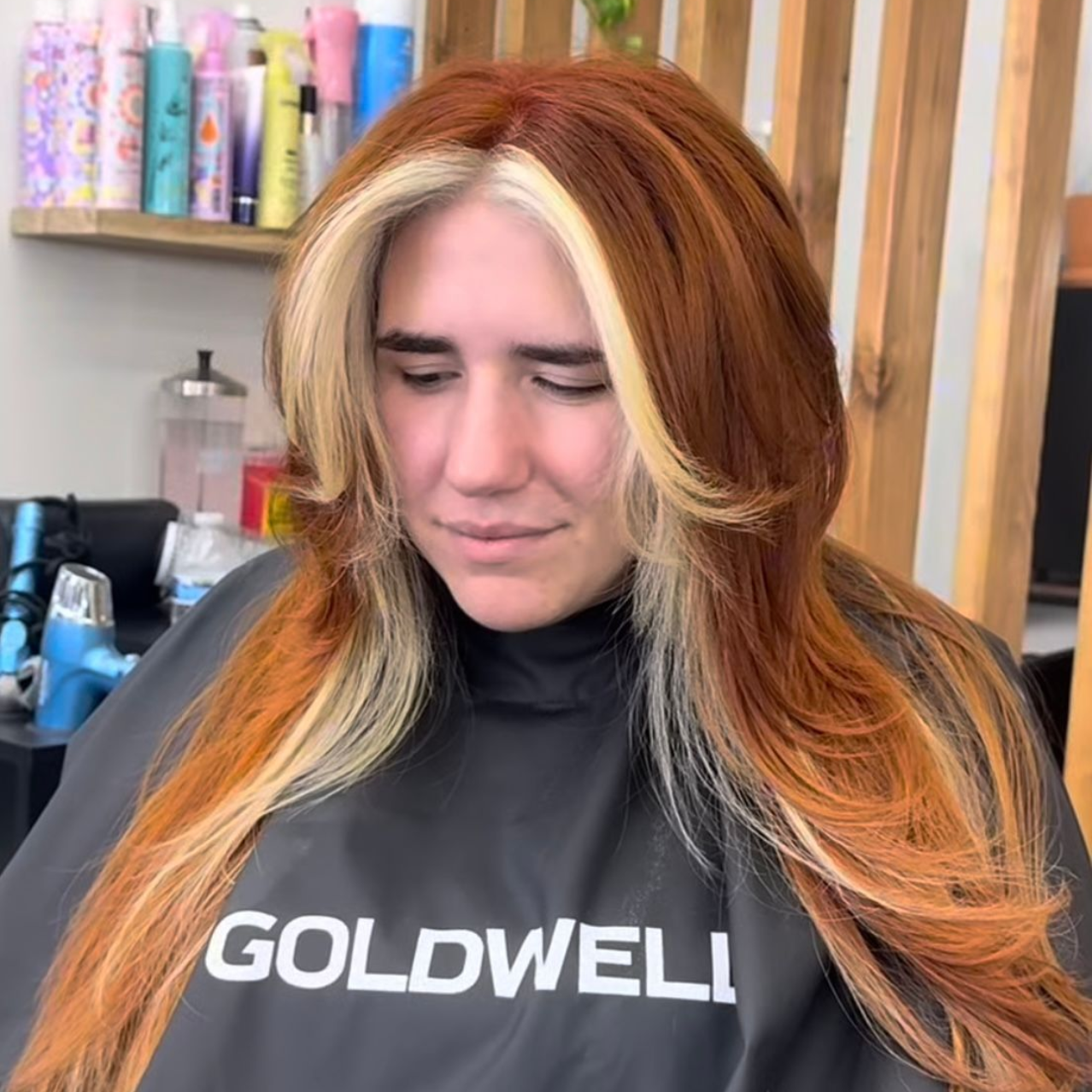 Tattoo artist styling a short-haired client's hair in a salon