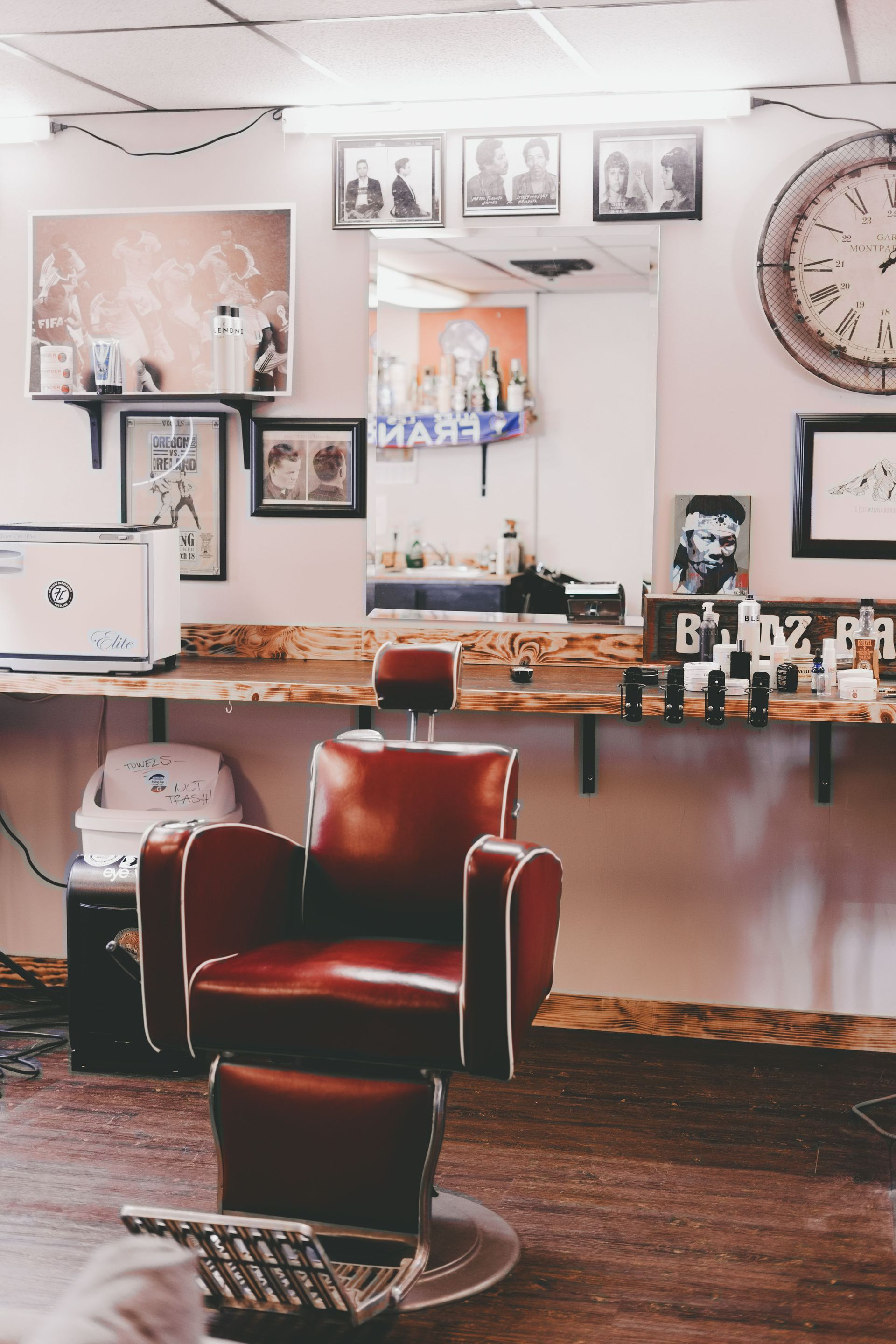 Inside of a classic barbershop, with pictures on the wall and a barber chair in the middle.