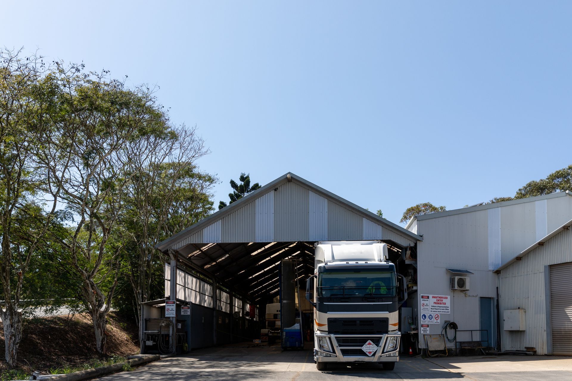 A truck is parked in front of a building with its doors open.