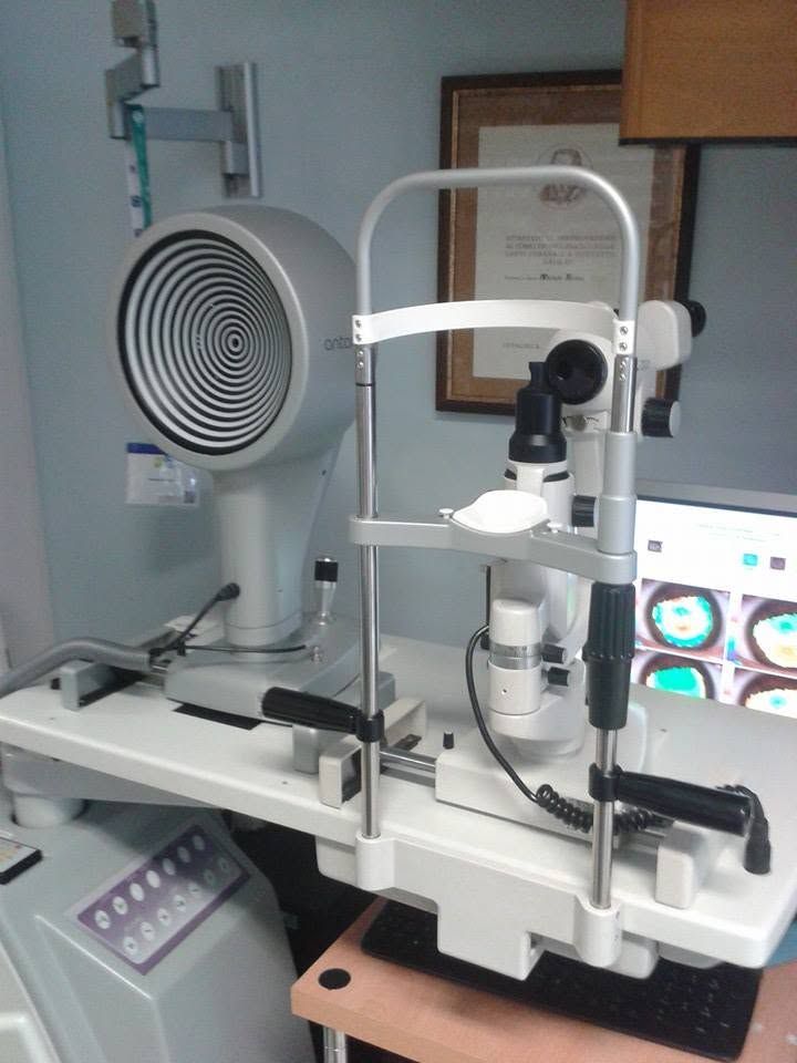 Sala per visite optometriche con apparecchio per esami della vista e display circolare per grafici.