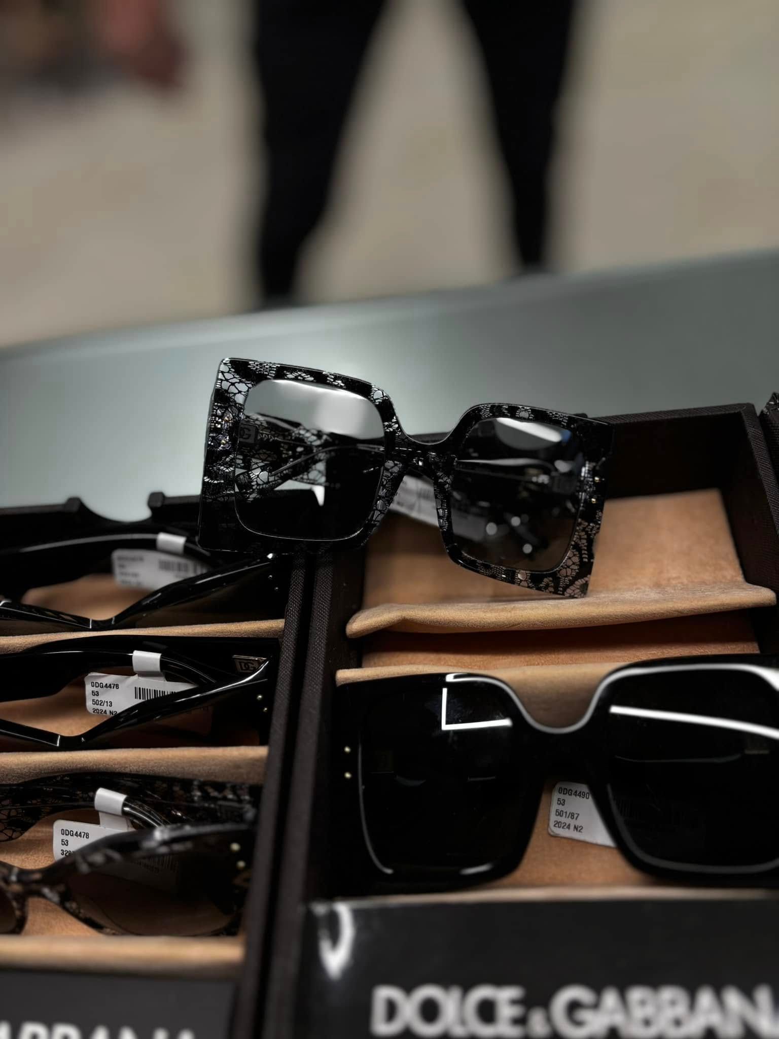 Occhiali da sole Dolce & Gabbana esposti in negozio, con montatura nera fantasia e custodia.