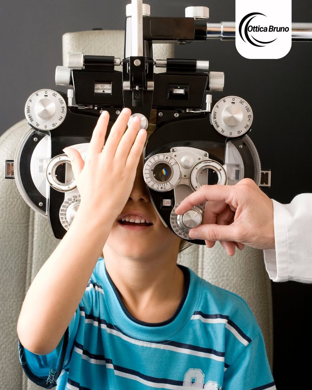 Bambino durante una visita oculistica con forottero e optometrista che regola le lenti.
