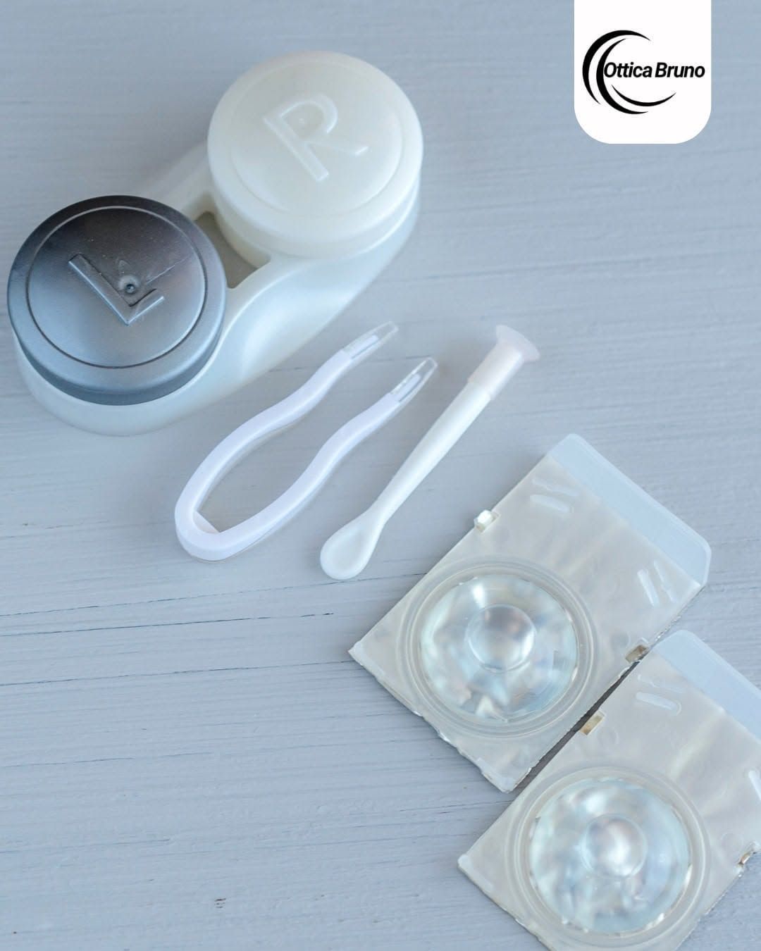 Kit cosmetico con vasetti, strumenti applicatori e due blister argentati su una superficie bianca