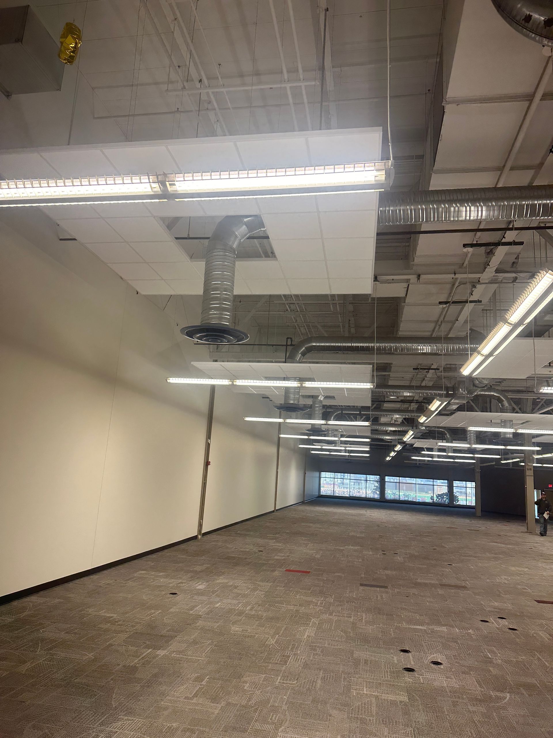 A large empty room with a lot of lights on the ceiling
