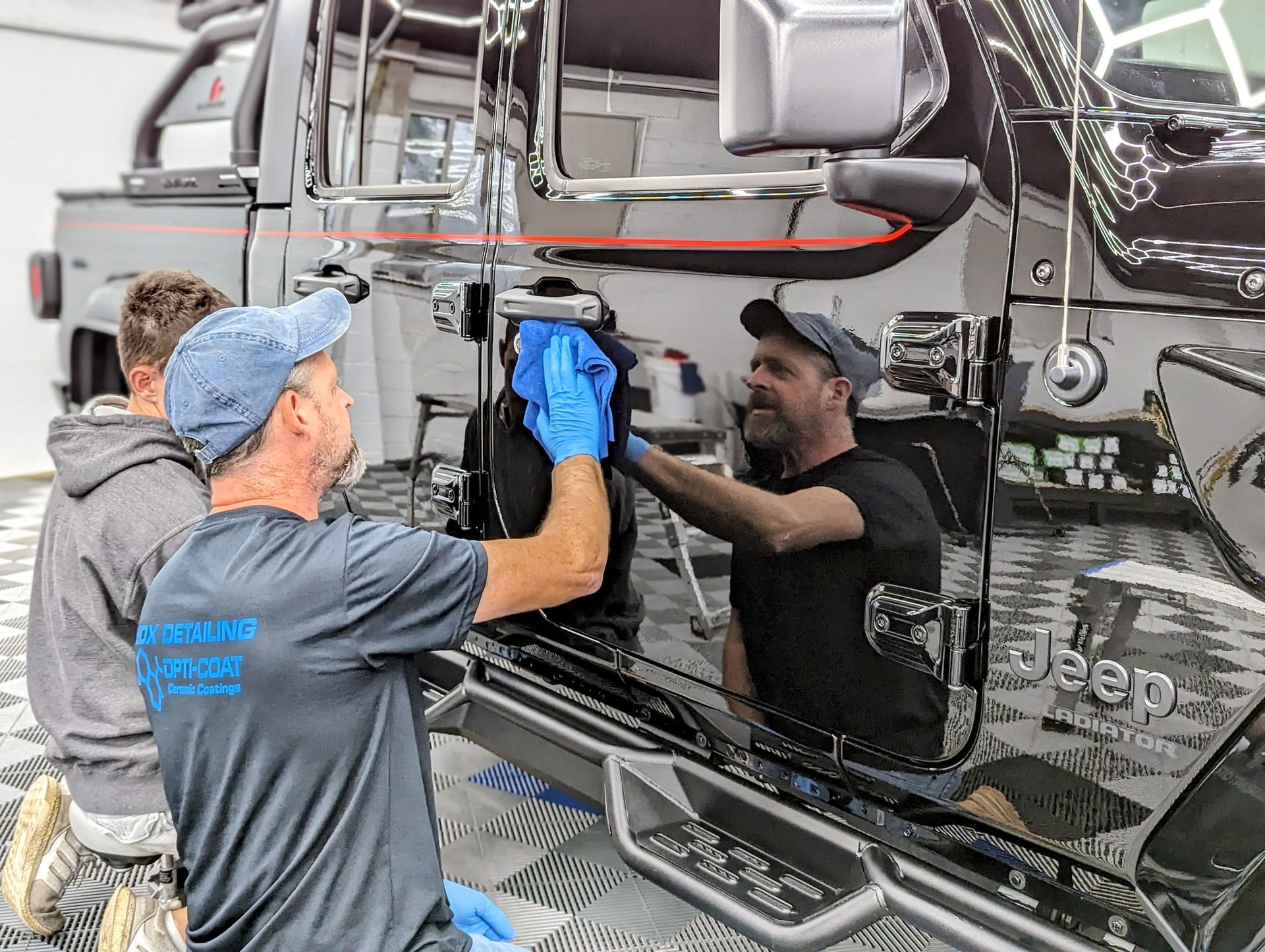 a group of men are cleaning a jeep in a garage .
