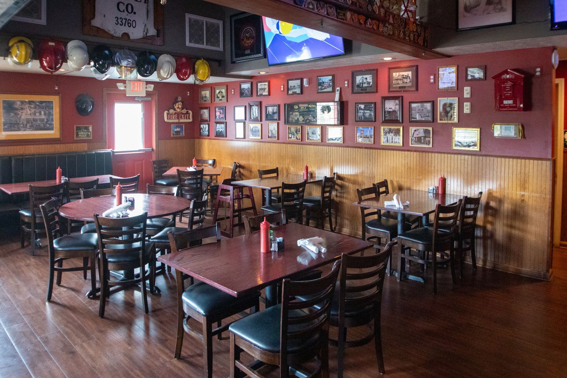 Interior of a restaurant with tables, chairs, and sports memorabilia on the walls.
