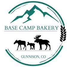 Logo for Base Camp Bakery in Gunnison, CO, featuring a mountain, moose, and wheat stalk within a green circle.