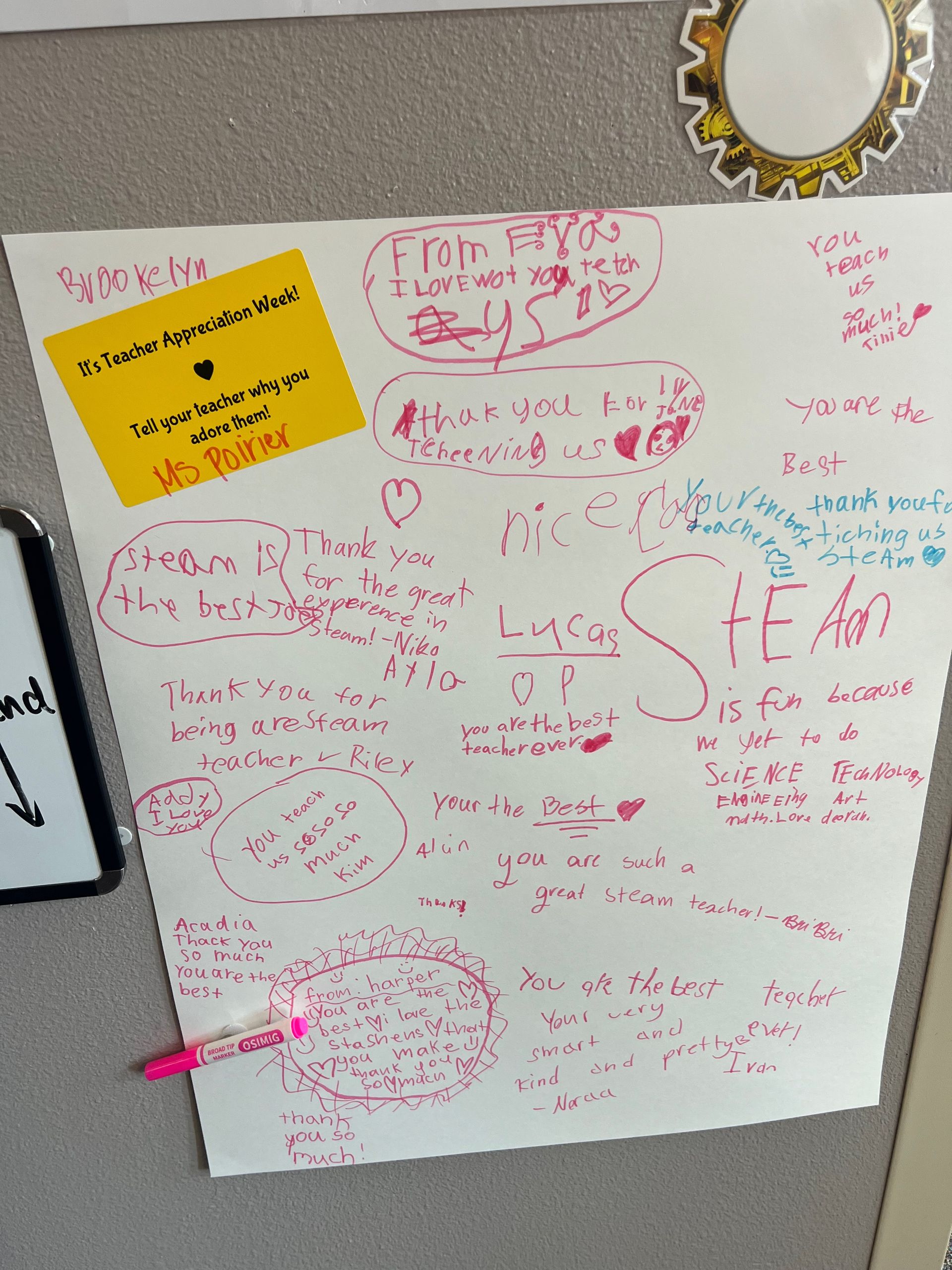White paper with pink marker signatures, and a yellow sticky note.