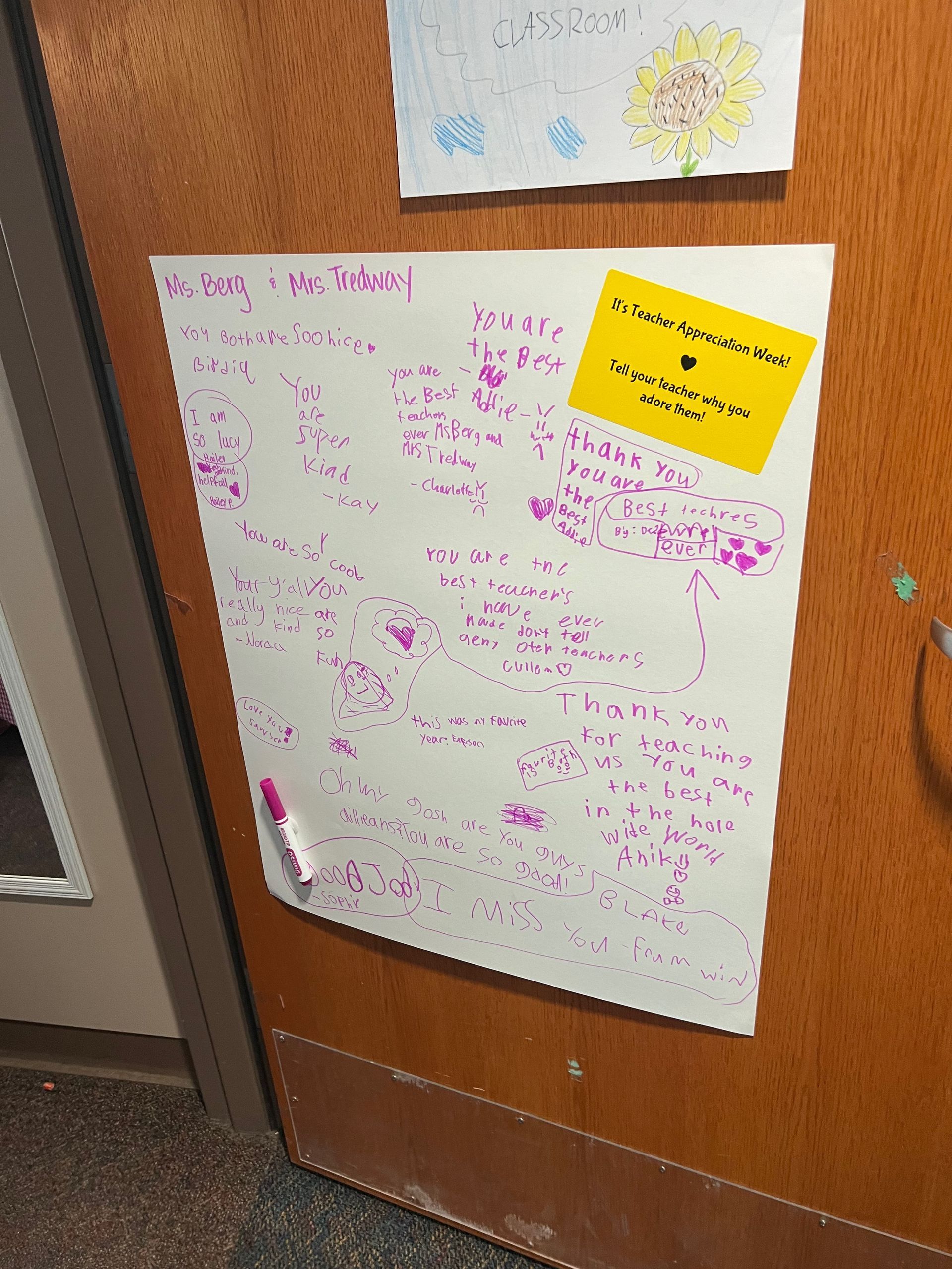 Whiteboard with pink writing and yellow sticky note attached to a wooden door.