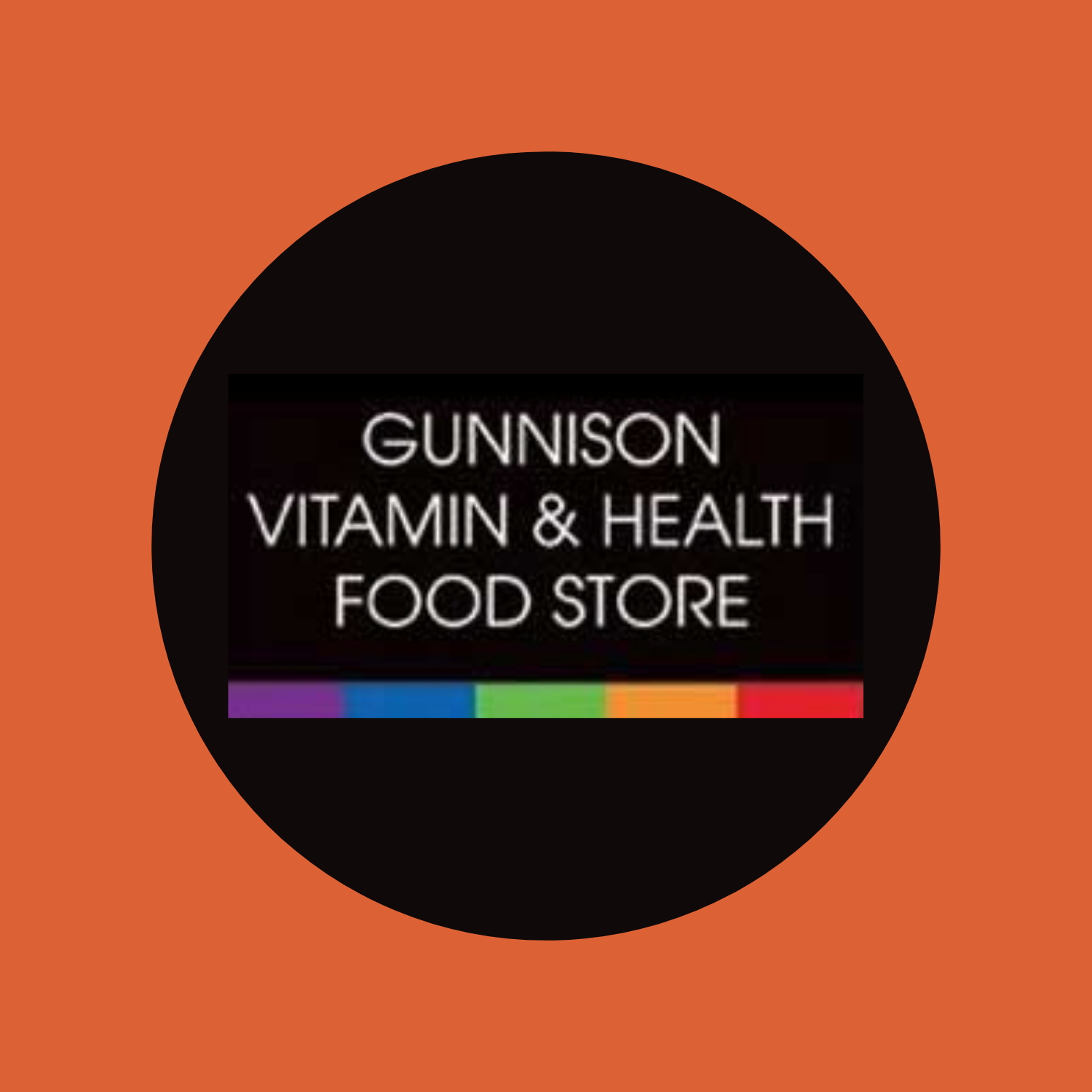 Logo for Gunnison Vitamin & Health Food Store: Black circle, text, rainbow bar.