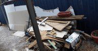 A pile of discarded construction materials, including wood planks, drywall, and other debris