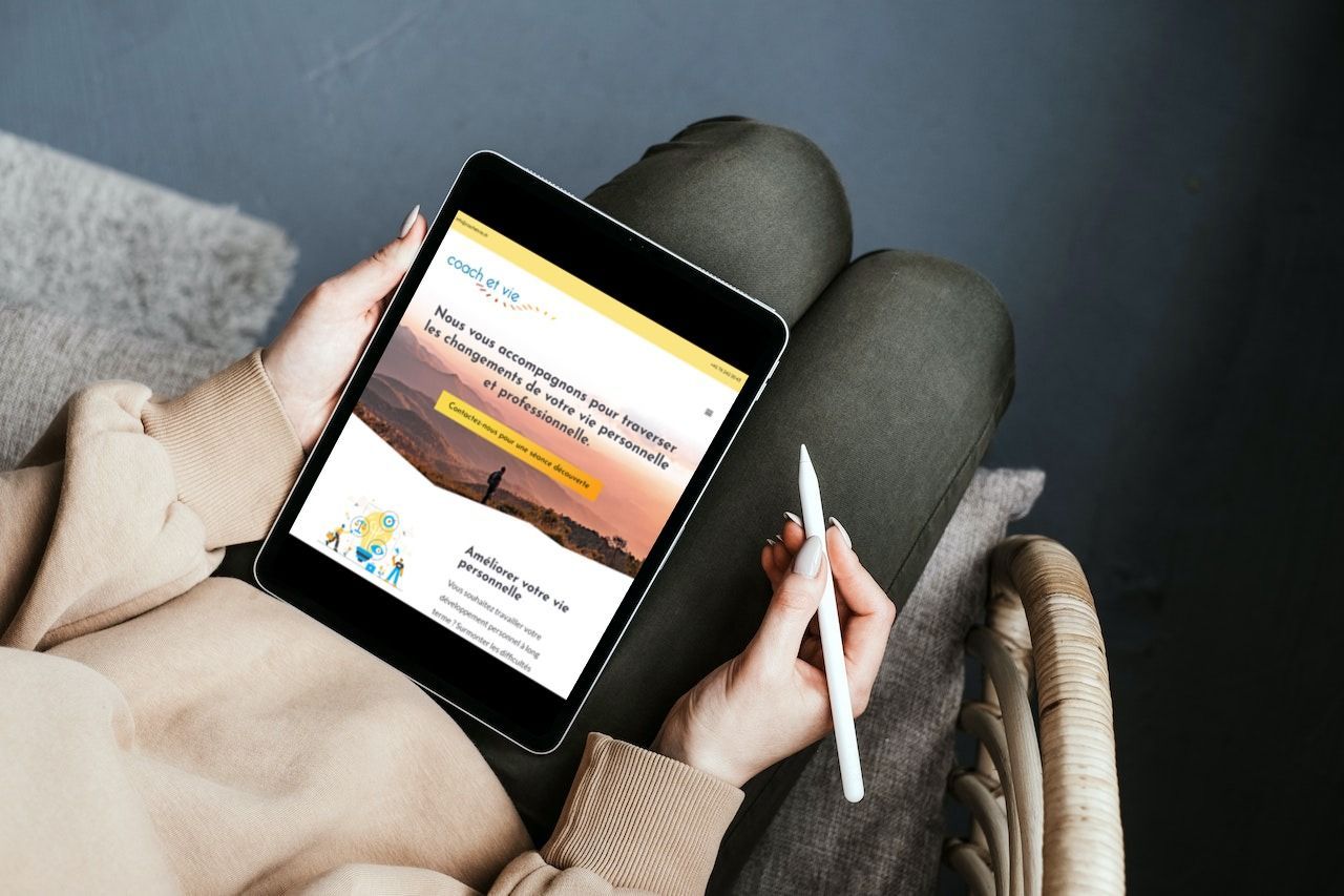Personne assise, tenant une tablette affichant un site web sur la nature et l'environnement, avec un stylet.