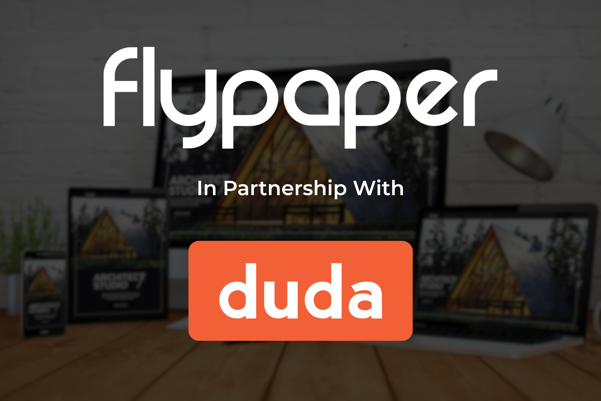 Flypaper and Duda partnership logo over a desk with computer monitors