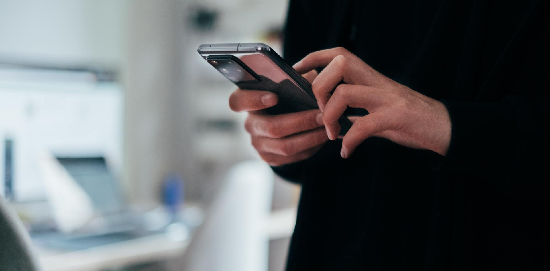 A person is holding a cell phone in their hands.
