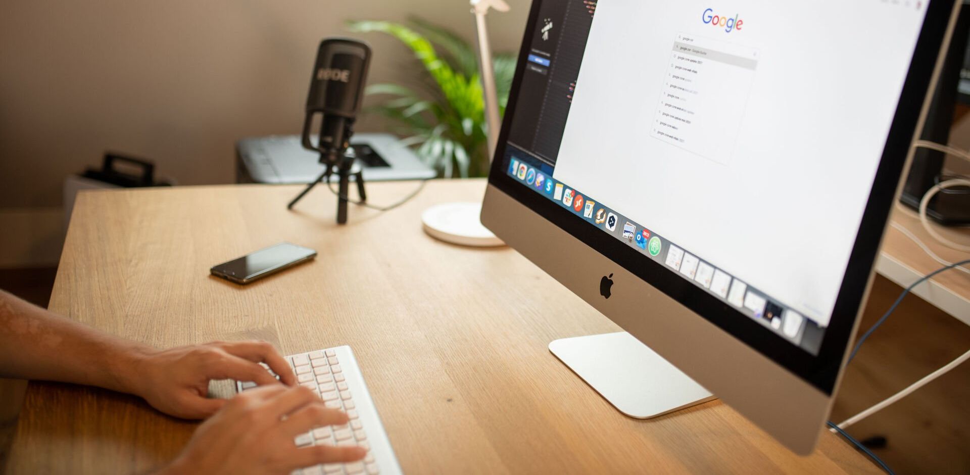 A person is typing on a keyboard in front of a computer.