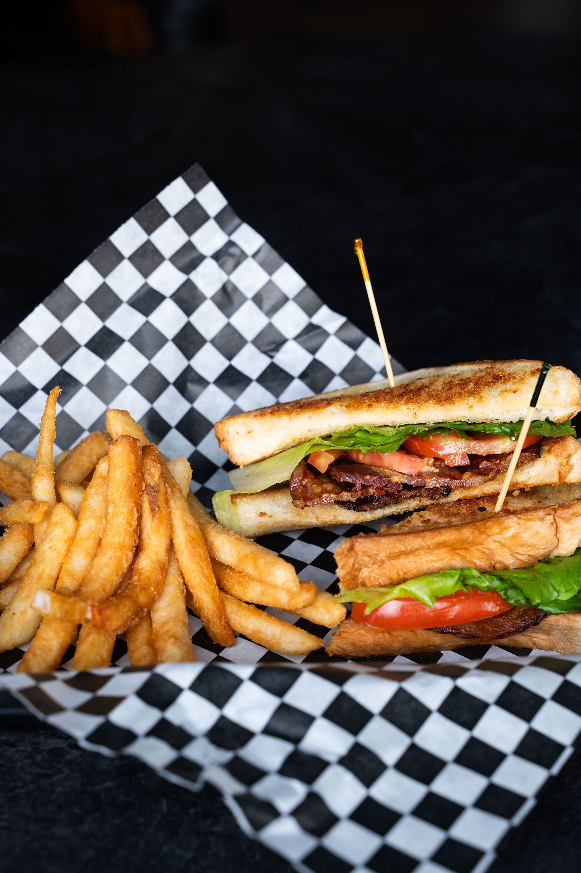 Burger sandwich with fries on black-and-white checkered paper