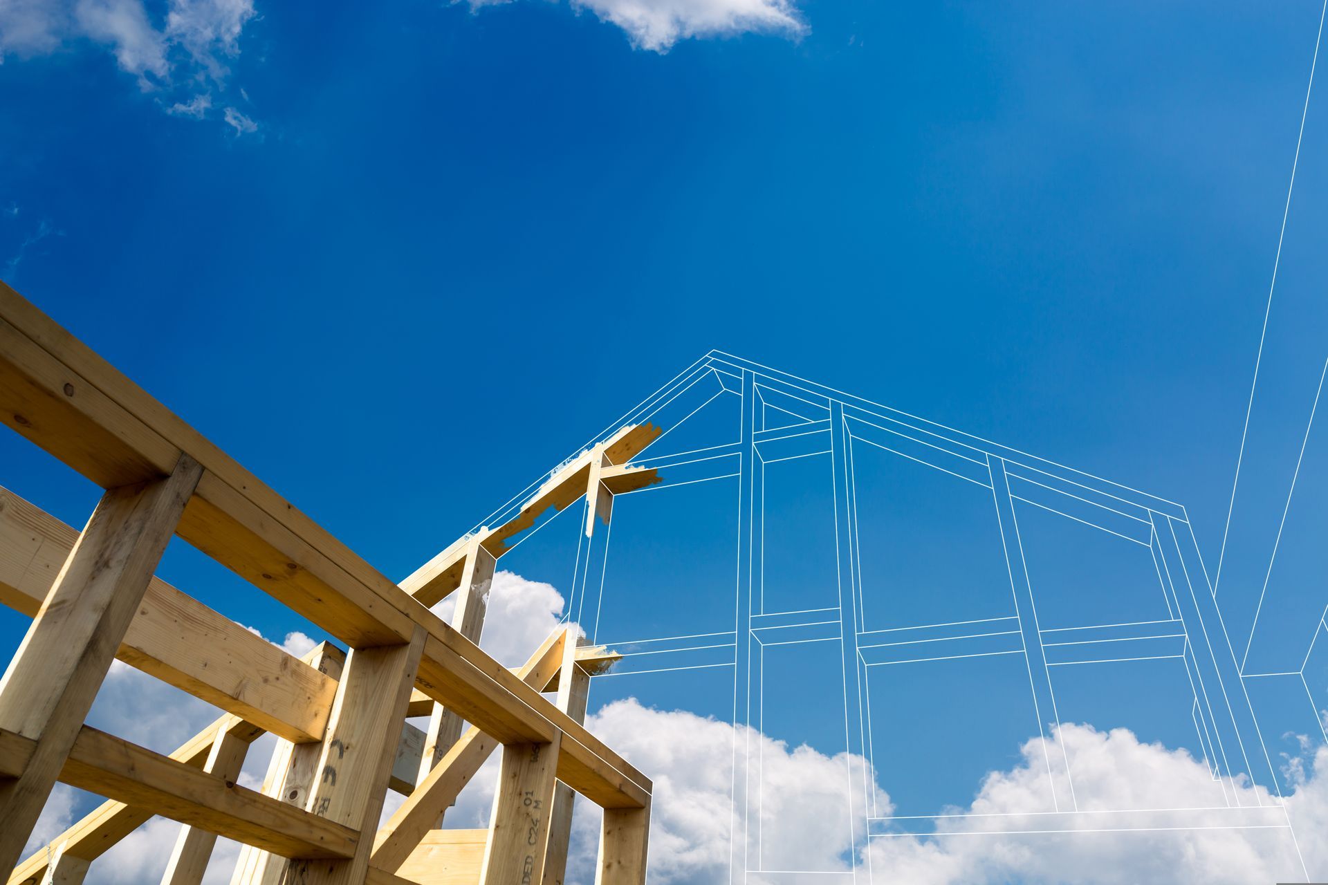 Wooden roof frame under construction against a bright blue sky with clouds