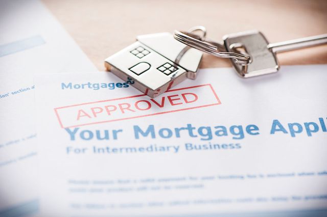 Approved mortgage application with house keys on the form