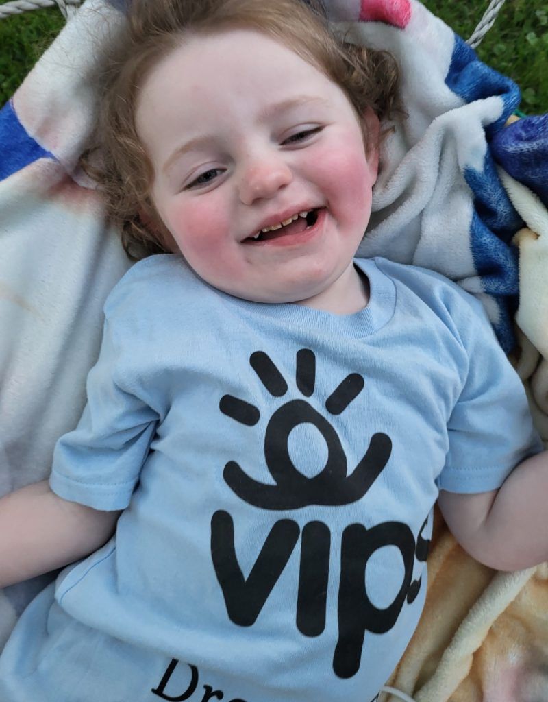 A child with a blue shirt on is smiling