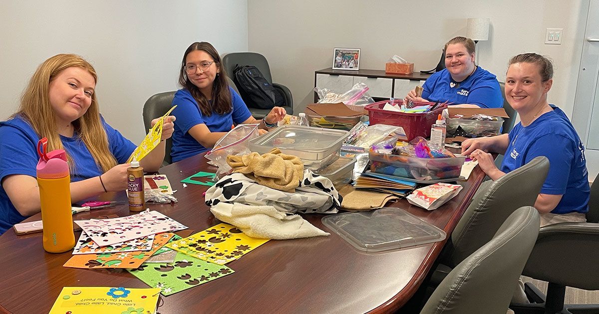 Volunteers from Forvis Mazars, LLP, make sensory books.