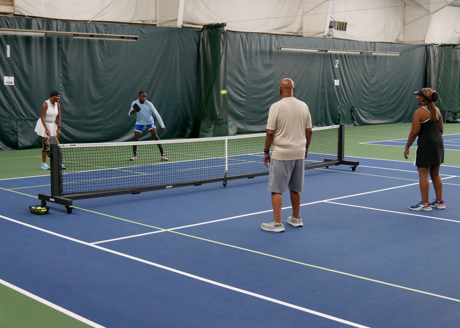 Pickleball doubles teams playing.